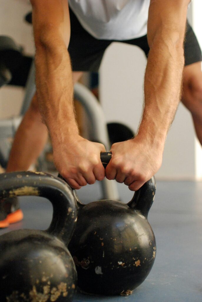 Mann steht konzentriert mit einer Kettlebell in der Hand