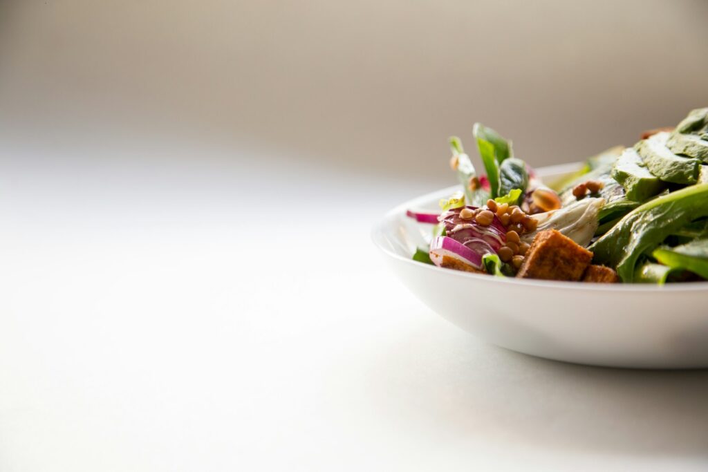 Schale mit Salat und Gemüse als Quelle für Ballaststoffe Sportler