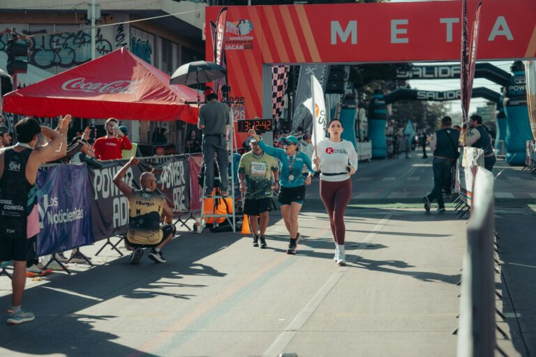Läufer überqueren die Ziellinie eines Straßenlaufs – gute Halbmarathon-Zeit im Visier