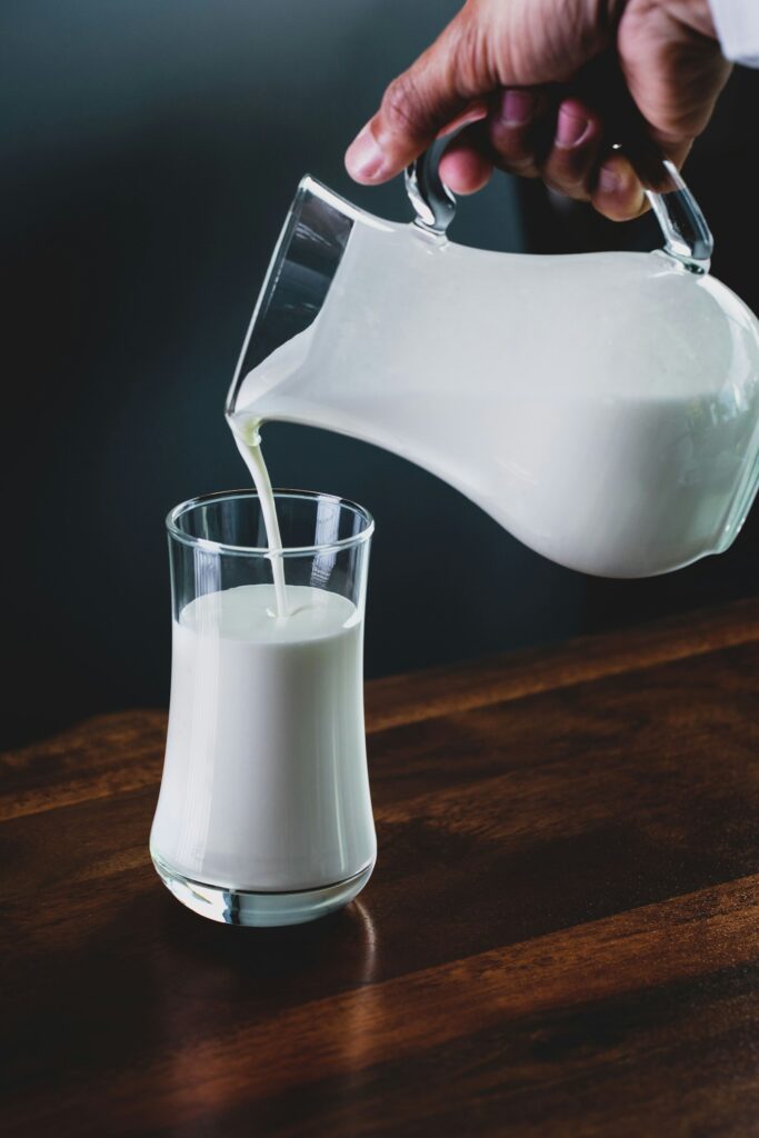 Milch wird in ein Glas gegossen und erhöht die Kalorien-Proteinshake-Bilanz