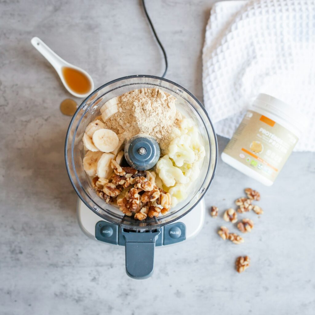 Standmixer mit Obst und Zutaten für einen Proteinshake
