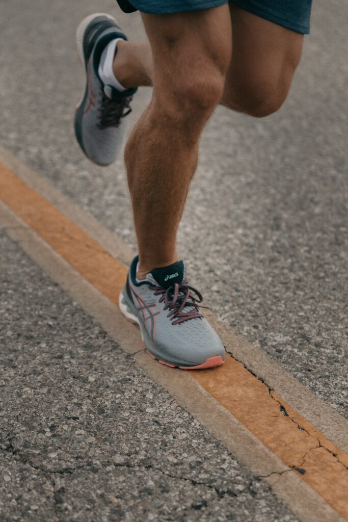 Laufschuhe kaufen: Läufer in Laufschuhen auf Asphalt