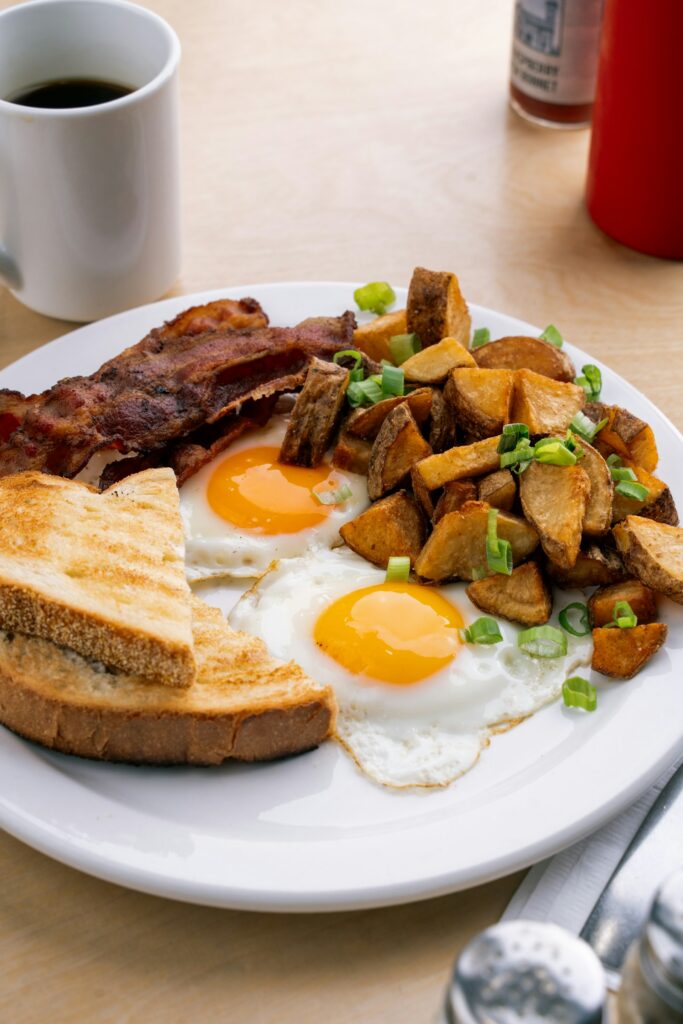 Weißer Teller mit Eiern und Toast als proteinreiches Frühstück, Muskelaufbau wann was essen