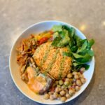Bowl mit Reis, Kichererbsen und Lachs als Beispiel für den Proteinbedarf Sportler