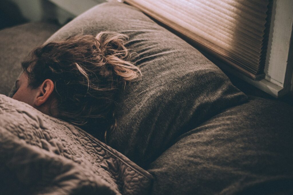 Frau schläft im Bett – Schlaf und Regeneration nach dem Training