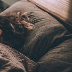 Frau schläft im Bett – Schlaf und Regeneration nach dem Training
