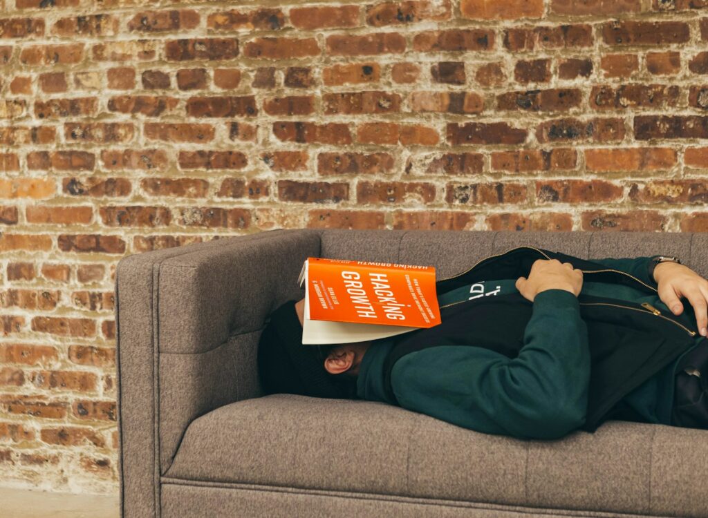 Person macht einen kurzen Powernap auf dem Sofa