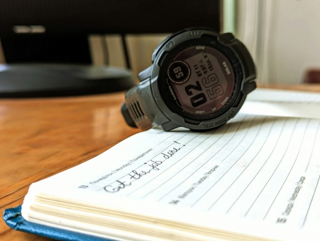 Armbanduhr liegt auf einem Notizbuch – Fortschritt im Trainingstagebuch messen